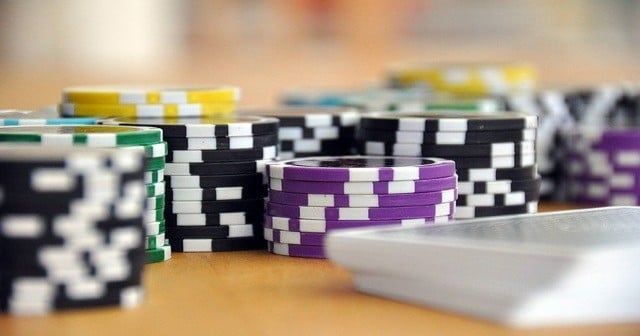 Stacks of different coloured betting chips and sports betting money